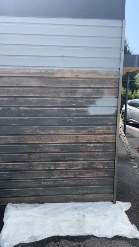 Bardage bois grisé en cours de traitement, avec une zone plus claire en haut, à Lyon