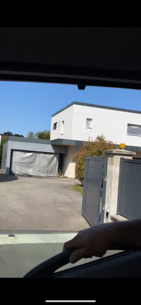 Maison contemporaine vue depuis l'entrée, garage protégé par une bâche, à Lyon
