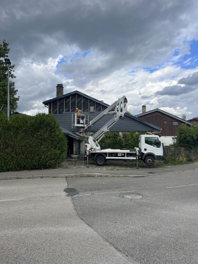 Nacelle élévatrice devant le pignon d'une maison pendant les travaux, à Lyon