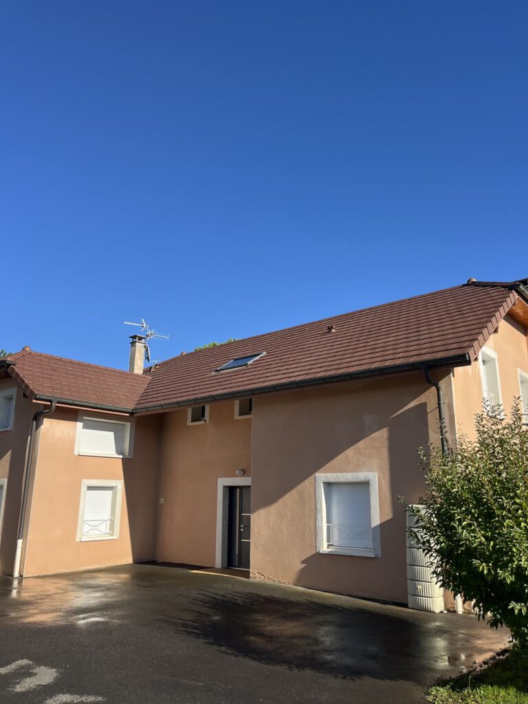 Autre façade de la maison, enduit propre et sol encore mouillé, à Lyon